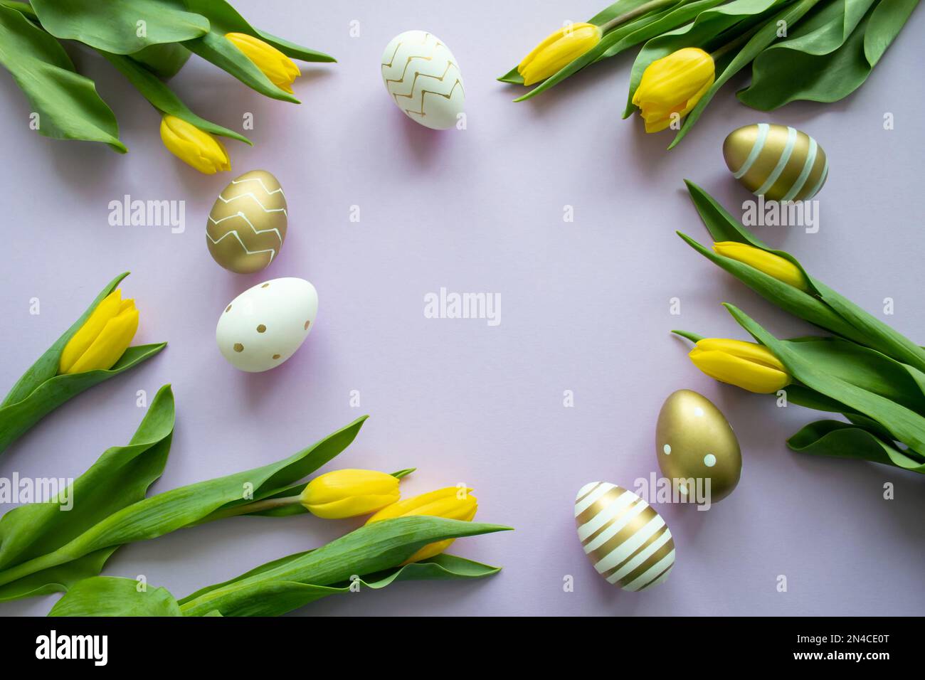 Oeufs de Pâques d'or, couleur blanche avec un motif et tulipes jaunes sur fond violet. Copier l'espace. Banque D'Images