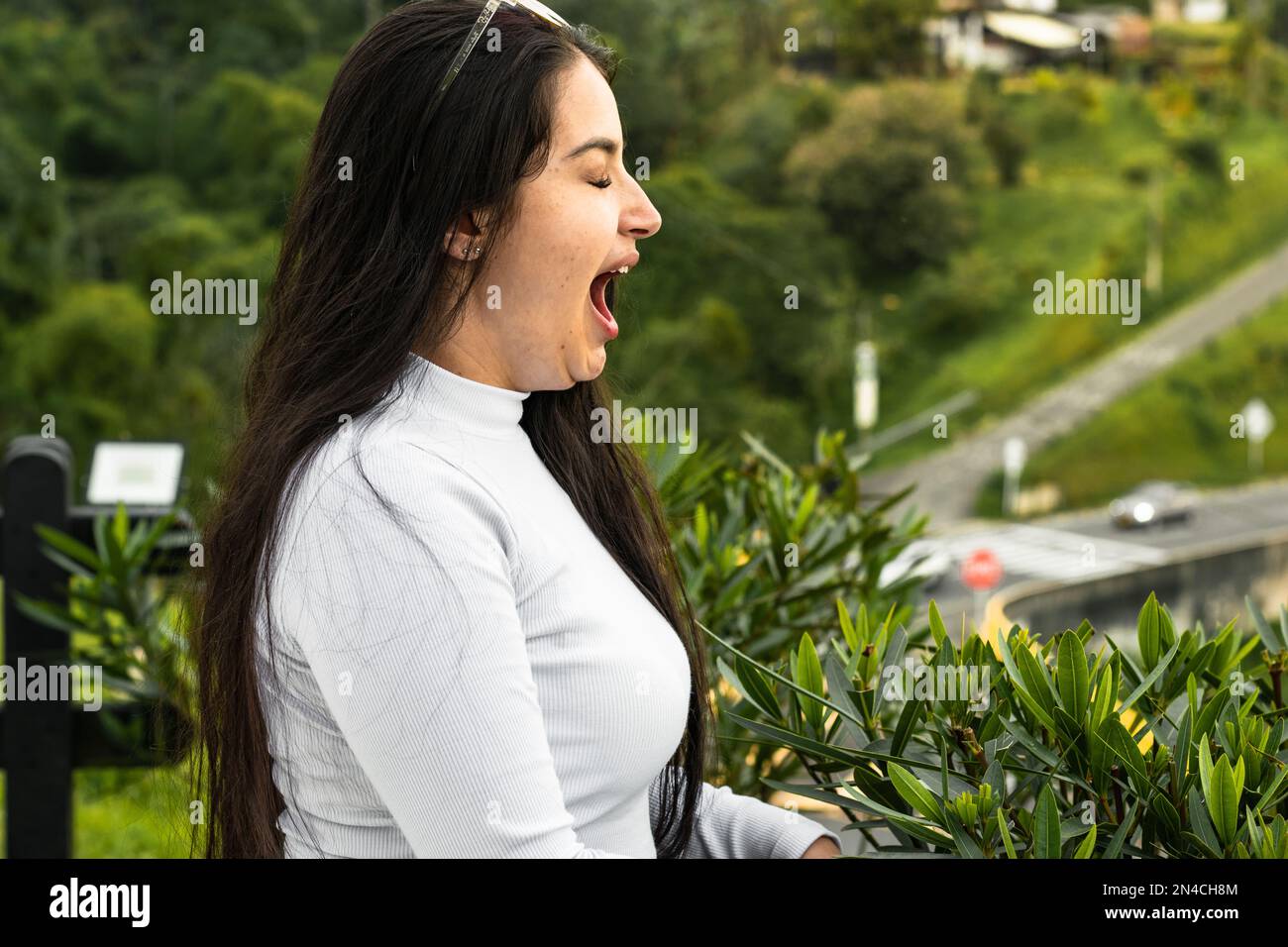 jeune femme latina, bâillant dans un parc extérieur. très endormi et fatigué. Banque D'Images
