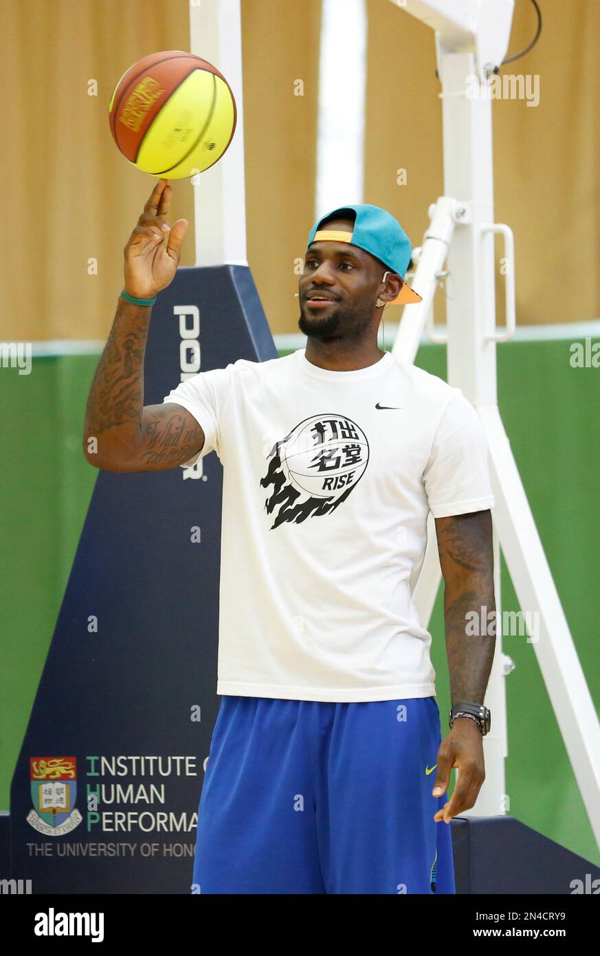 NBA star LeBron James shows his skills during a basketball clinic in Hong Kong as part of his China tour Wednesday, July 23, 2014. Earlier this month, James left the Miami Heat after four seasons and four trips to the NBA Finals and re-signed with the Cavaliers, where his career began. (AP Photo/Kin Cheung) Banque D'Images