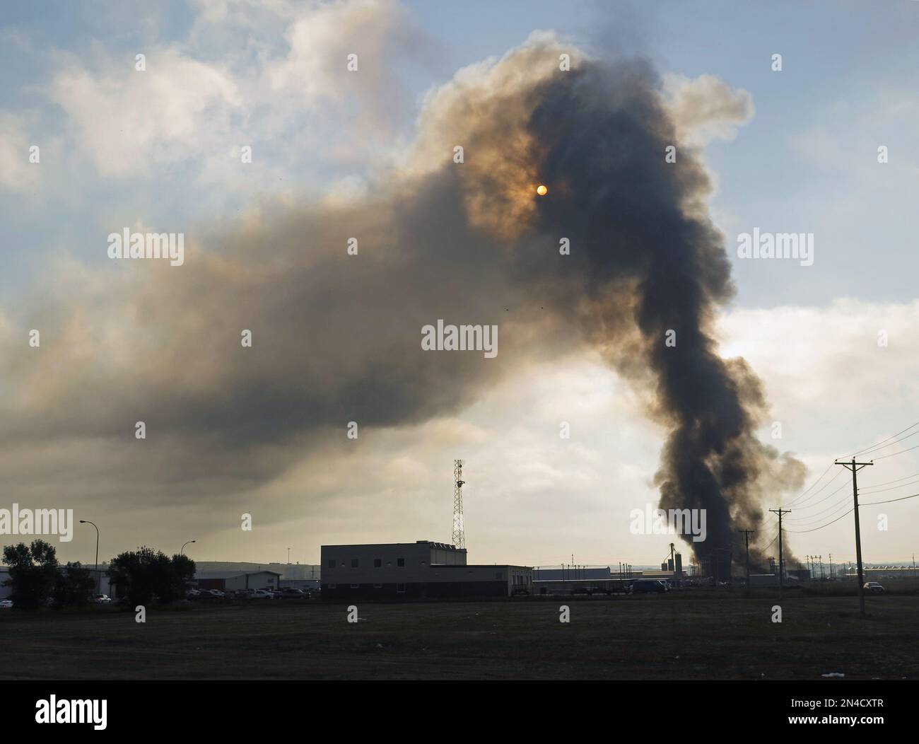 Smoke rises from the site of a fire in an industrial area of Williston, N.D. on Tuesday, July 22, 2014. Authorities have set up an evacuation zone within a half-mile radius of Red River Supply, the site of the fire. No injuries were immediately reported. Red River Supply provides services to oil companies working in North Dakota's oil patch. (AP Photo/Josh Wood) Banque D'Images