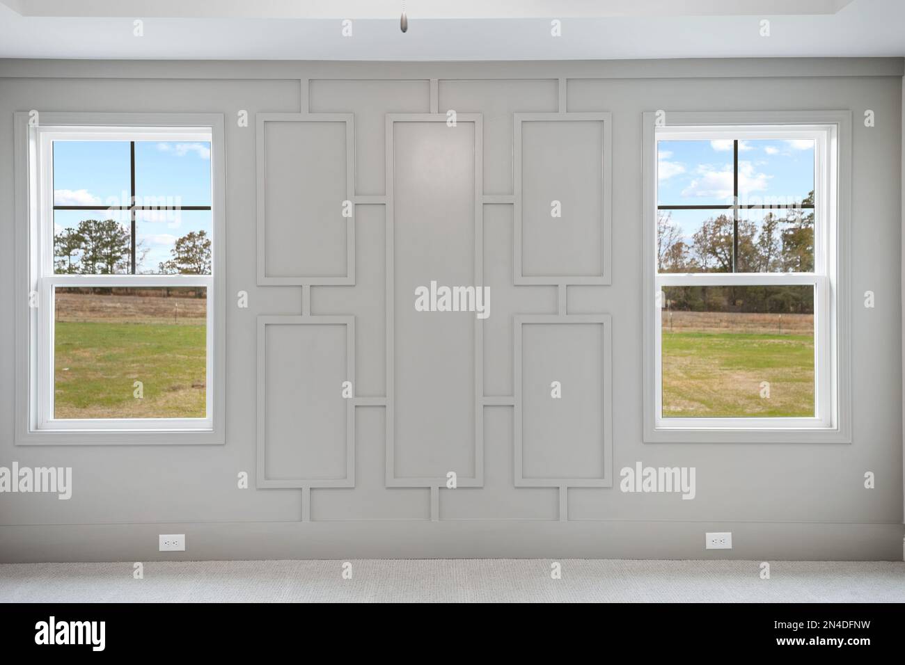 Une chambre principale vide avec des murs et des fenêtres gris avec vue sur le parc Banque D'Images