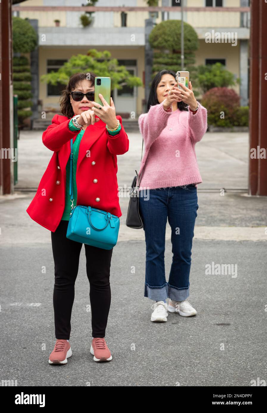 Deux femmes vietnamiennes touristes prennent des selfies à Mong Cai, Vietnam, à la frontière avec la Chine. Banque D'Images