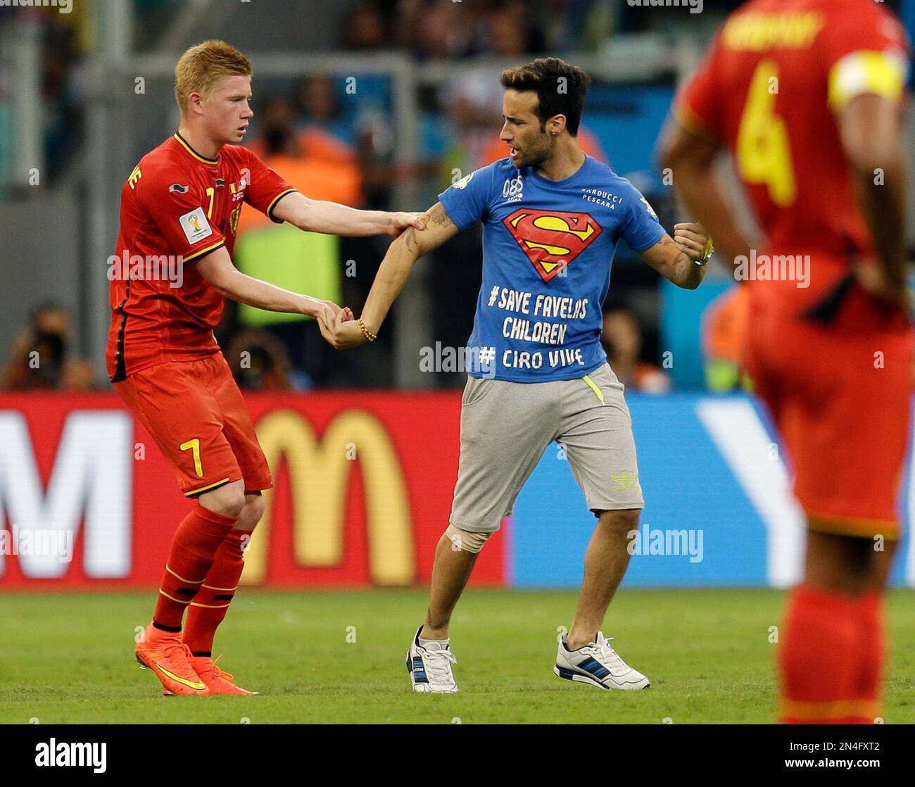 Belgium's Kevin De Bruyne holds on to a spectator who ran on to the pitch during the World Cup round of 16 soccer match between Belgium and the USA at the Arena Fonte Nova in Salvador, Brazil, Tuesday, July 1, 2014. (AP Photo/Natacha Pisarenko) Banque D'Images