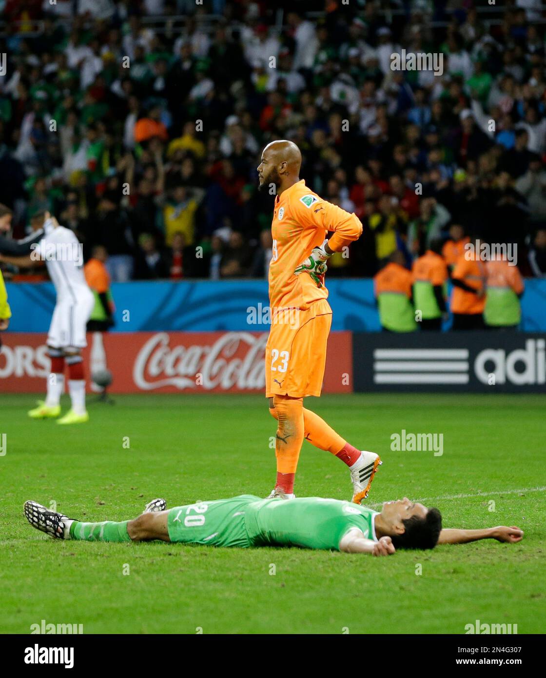 Algeria's goalkeeper Rais M’Bolhi, top, and his teammate Aissa Mandi react after Germany's Mesut Ozil scored his side's second goal during the World Cup round of 16 soccer match between Germany and Algeria at the Estadio Beira-Rio in Porto Alegre, Brazil, Monday, June 30, 2014. Germany defeated Algeria 2-1 to advance to the quarterfinals. (AP Photo/Kirsty Wigglesworth) Banque D'Images