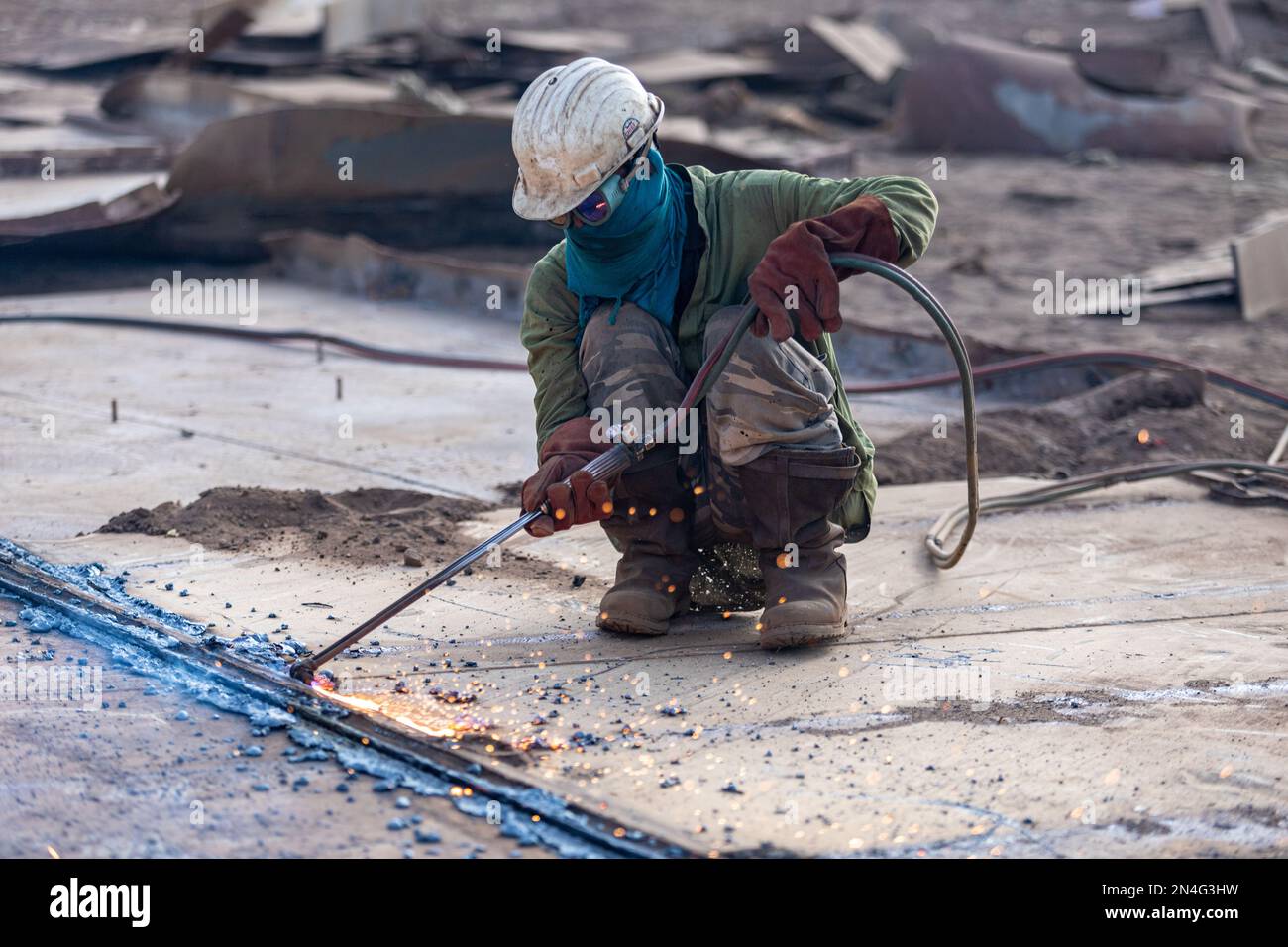 Gadani Pakistan août 2021, un travailleur portant un casque de sécurité coupant une tôle avec un arc de soudage, des travaux au chantier de bfreuillage des navires, Labor Day Pak Banque D'Images