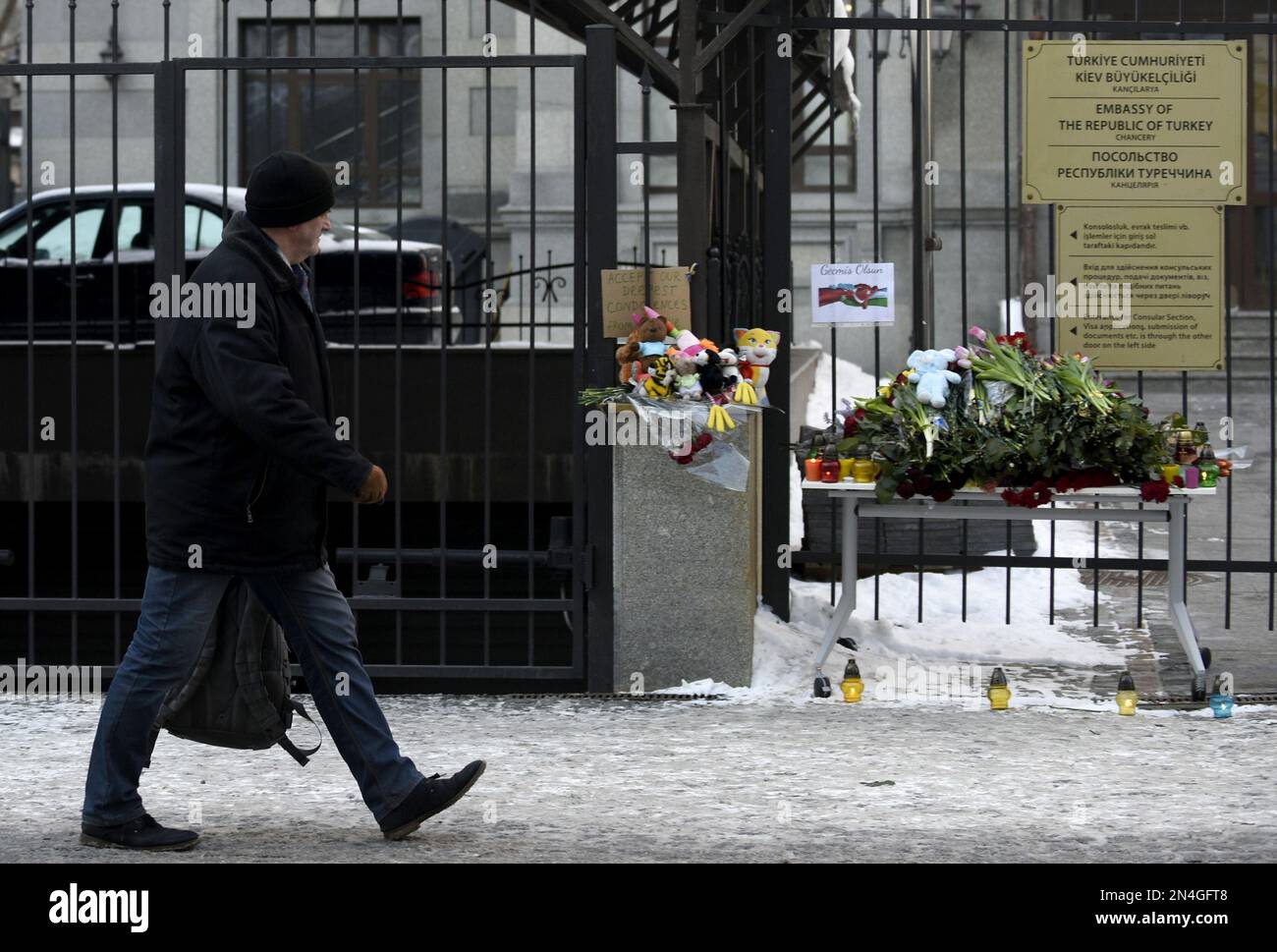 KIEV, UKRAINE - 8 FÉVRIER 2023 - Un homme passe devant les fleurs portées en souvenir des victimes du tremblement de terre à l'extérieur de l'ambassade de la République o Banque D'Images