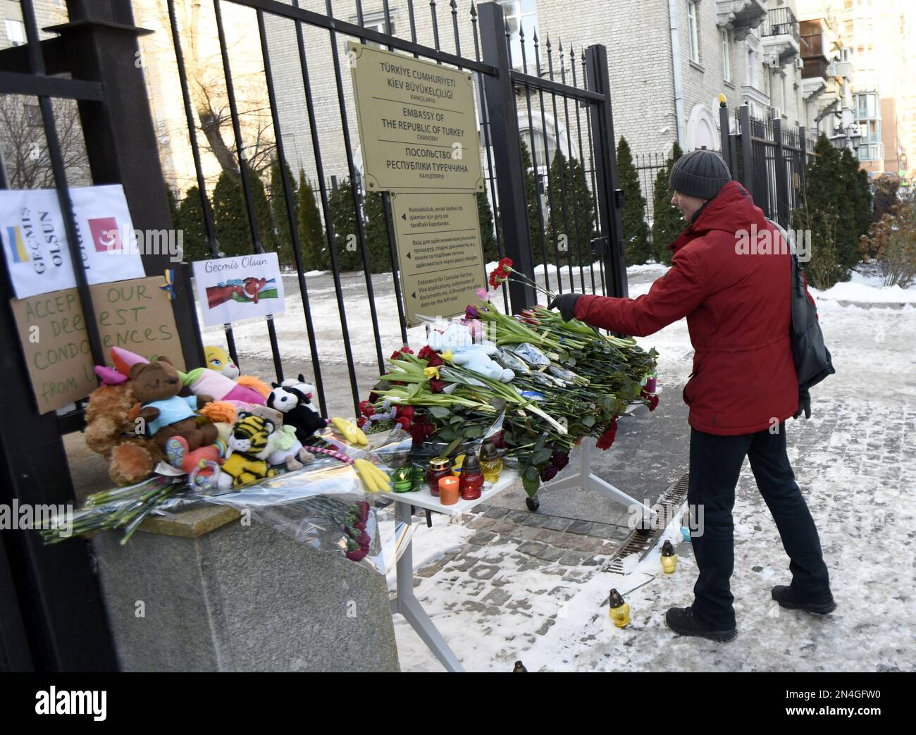 KIEV, UKRAINE - 8 FÉVRIER 2023 - Un homme laisse des œillets rouges en souvenir des victimes du tremblement de terre à l'extérieur de l'ambassade de la République de Turquie Banque D'Images