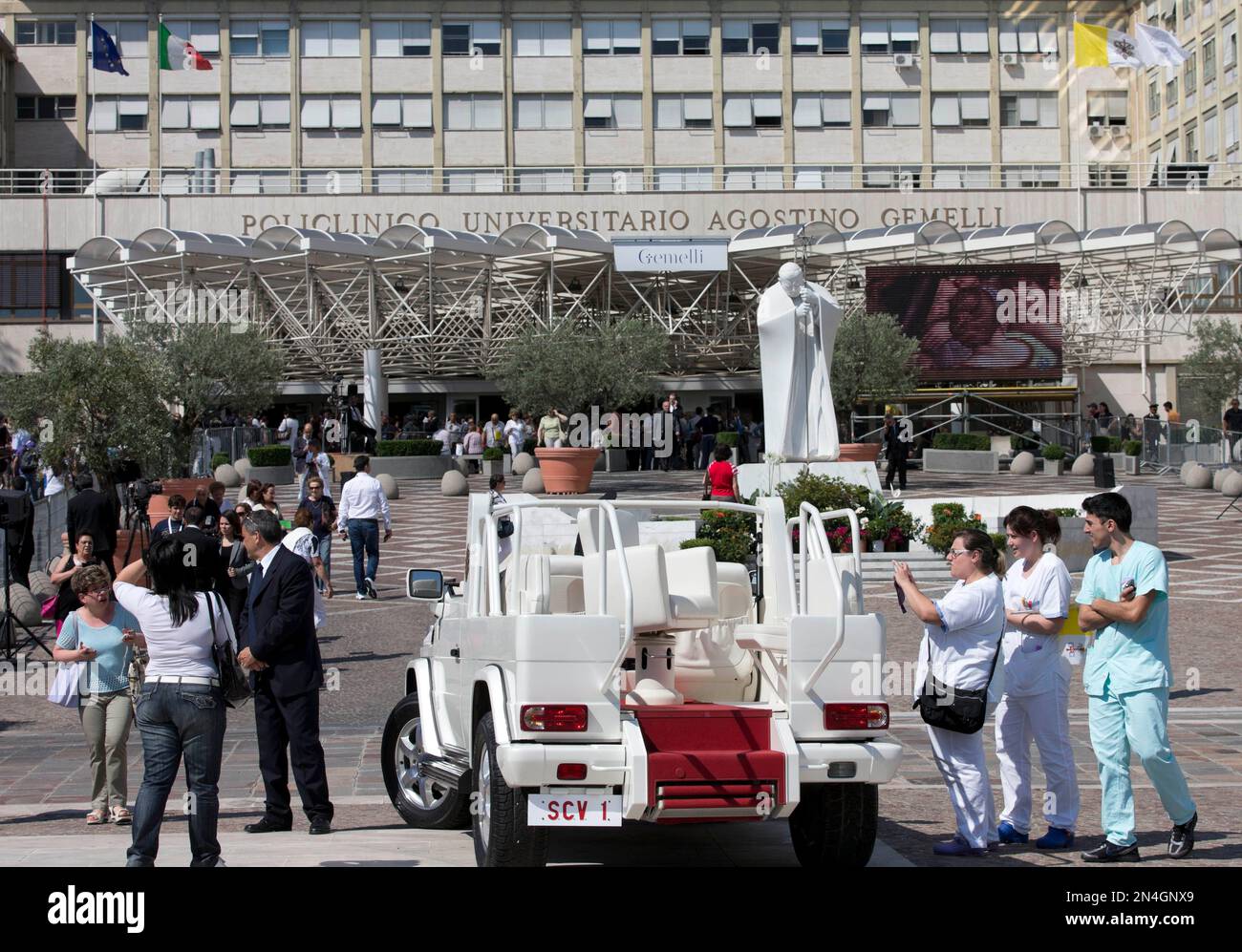 Faithful take photos in front of Pope mobile after the announcement that Pope Francis visit to the Policlinico Gemelli Hospital was canceled, in Rome, Friday, June 27, 2014. Pope Francis has canceled a planned visit to one of Rome's main hospitals — the latest in a string of ailments that have raised questions about the 77-year-old pontiff's health. Francis had been due to visit the Gemelli hospital and celebrate a Mass there Friday afternoon. (AP Photo/Alessandra Tarantino) Banque D'Images