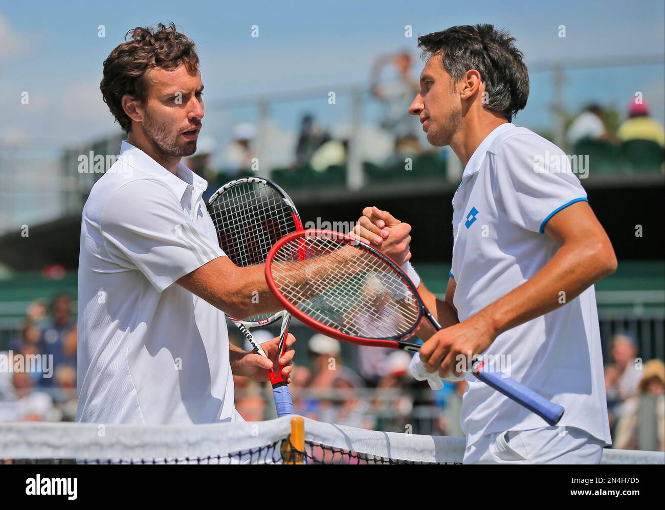 Sergiy Stakhovsky of Ukraine, right, shakes hands with Ernests Gulbis of Latvia, left, following their men's singles match at the All England Lawn Tennis Championships in Wimbledon, London, Wednesday, June 25, 2014. (AP Photo/Pavel Golovkin) Banque D'Images