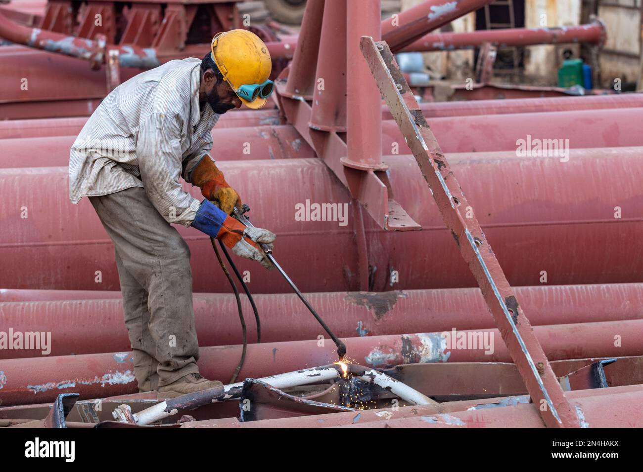 Gadani Pakistan août 2021, un travailleur portant un casque de sécurité coupant une tôle avec un arc de soudage, des travaux au chantier de bfreuillage des navires, Labor Day Pak Banque D'Images