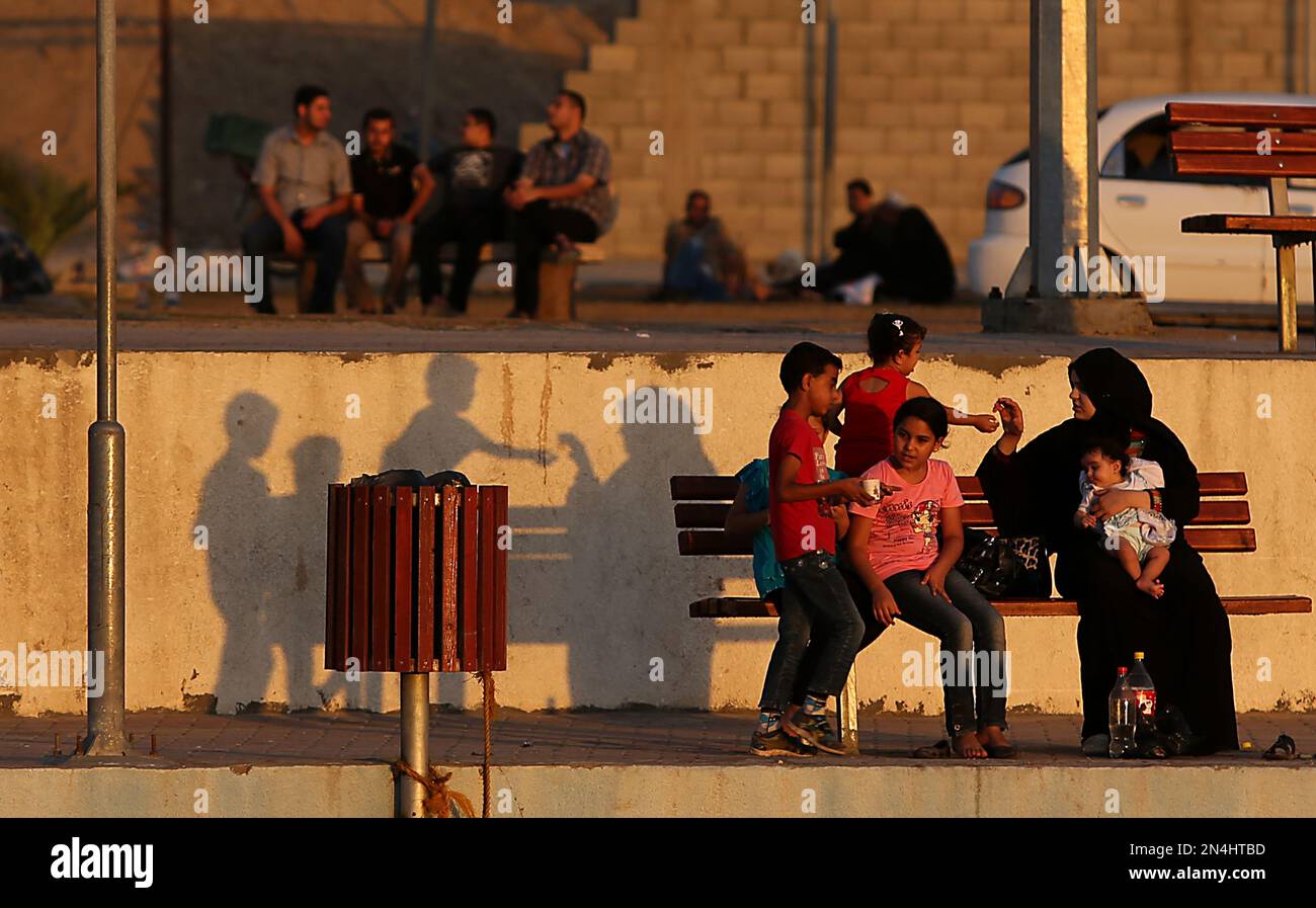 Palestinians sit by the Mediterranean Sea water at the port in Gaza City, Sunday, June 22, 2014. The sea and its solo port are the prime summer escape for the 1.8 million residents of the Gaza Strip, which is cut off from the world by the near-total closure of Rafah crossing point, Gaza's main gate to the outside world. (AP Photo/Hatem Moussa ) Banque D'Images