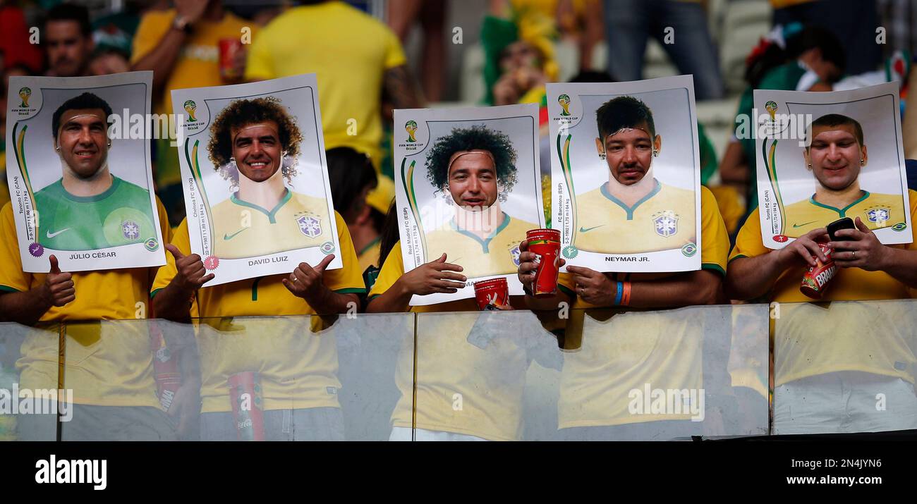 Brazilian fans wear cut out poster of Brazil national players before the group A World Cup soccer match between Brazil and Mexico at the Arena Castelao in Fortaleza, Brazil, Tuesday, June 17, 2014. (AP Photo/Eduardo Verdugo) Banque D'Images