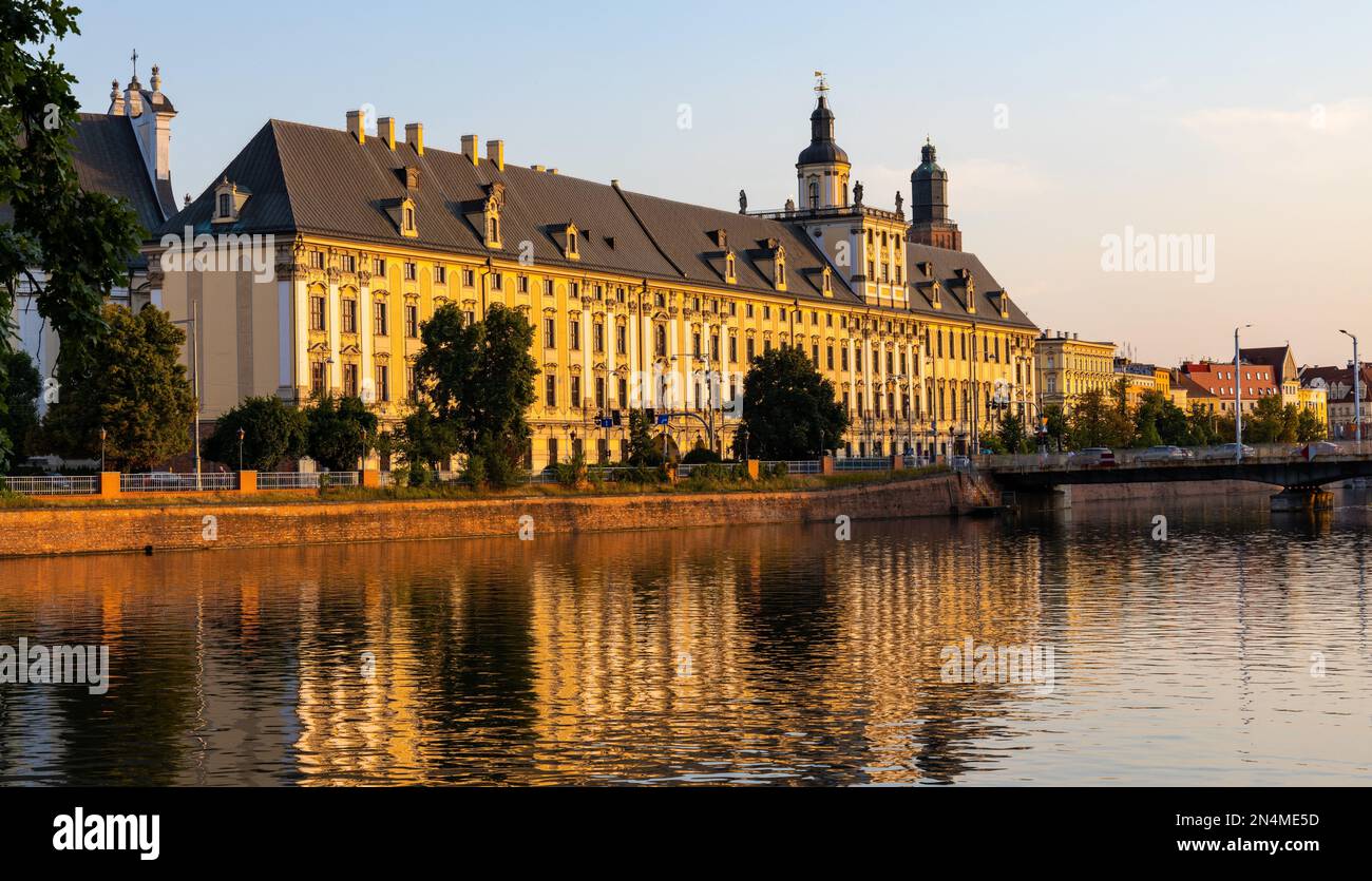 Wroclaw, Pologne - 19 juillet 2022: Quartier historique de la vieille ville avec l'université de Wroclaw et la rue Grodzka remblai au coucher du soleil sur la rivière Warta Banque D'Images