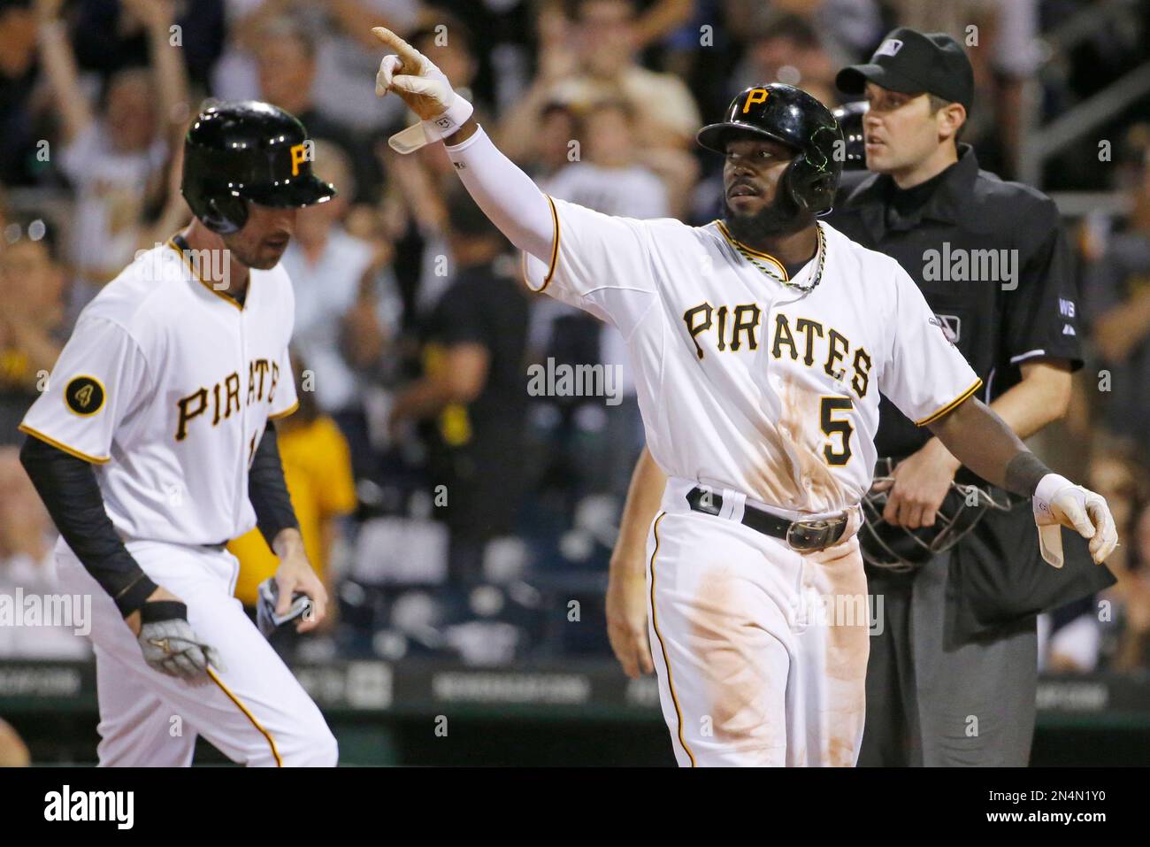 Pittsburgh Pirates' Josh Harrison (5) points to teammate Russell Martin on second after scoring on Martin's three-run double off Milwaukee Brewers relief pitcher Tyler Thornburg during the sixth inning of a baseball game in Pittsburgh Friday, June 6, 2014. (AP Photo/Gene J. Puskar) Banque D'Images