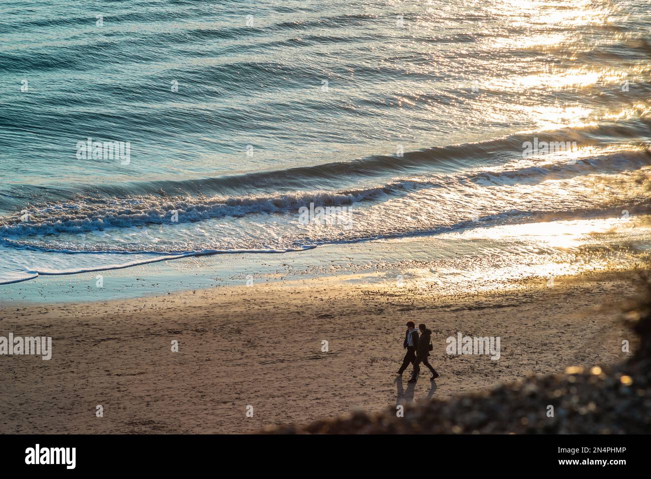 Deux personnes marchant le long de la plage à Hengistbury Head à Dorset, Angleterre, Royaume-Uni Banque D'Images