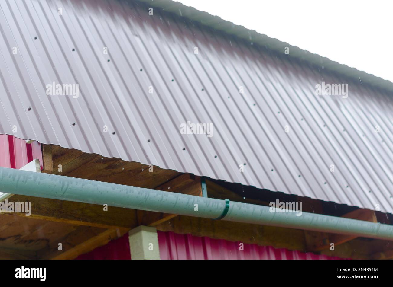 L'eau du toit du village coule dans la gouttière pour la collecte et l'enlèvement. Recueillir l'eau potable des peuples du Nord de Yakutia. Banque D'Images