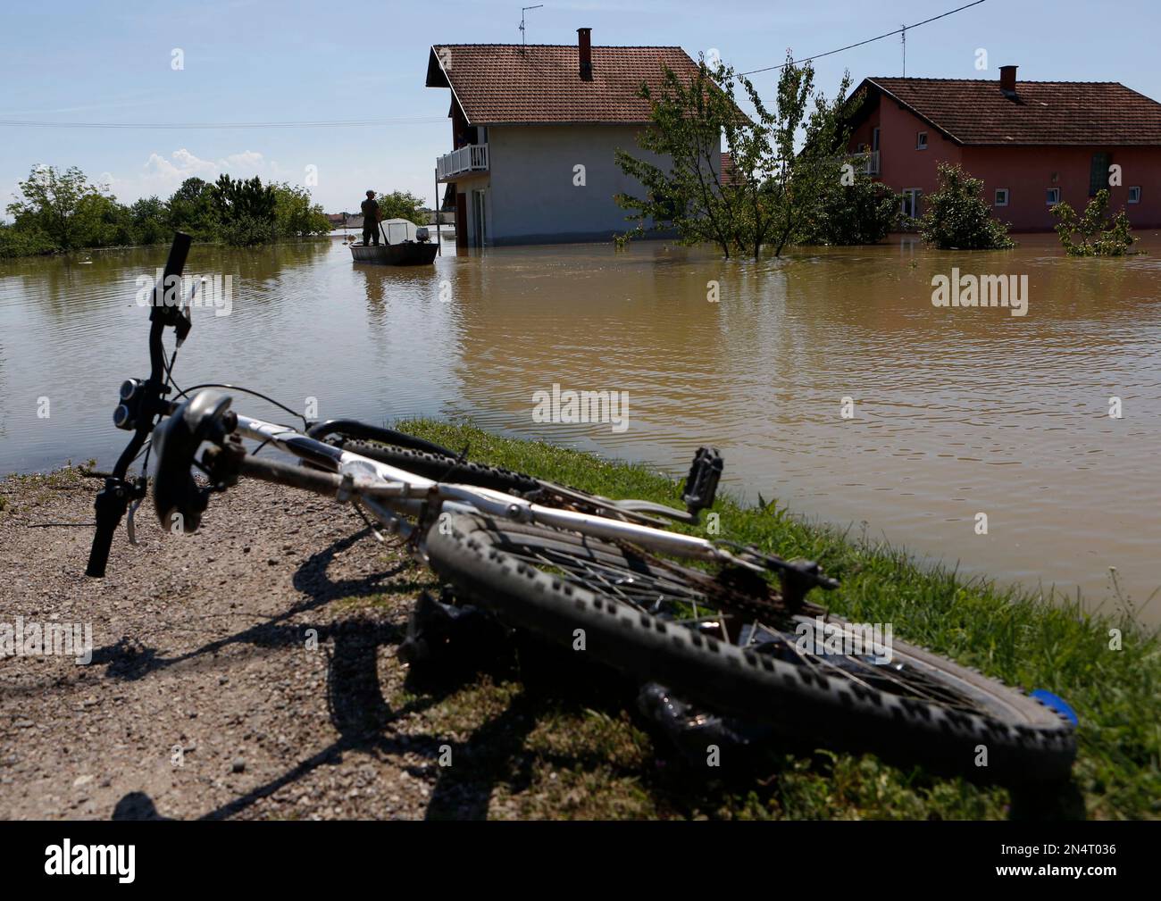 A man paddles toward his house in the village of Domaljevac near the Bosnian town of Orasje along river Sava, 200 kms north of Bosnian capital of Sarajevo, on Wednesday, May 21, 2014. Floodwaters receded Wednesday in Bosnia and Serbia, just enough to reveal the next shock: recovery from the historic flood will probably cost billions of euros that neither of the countries has. (AP Photo/Amel Emric) Banque D'Images