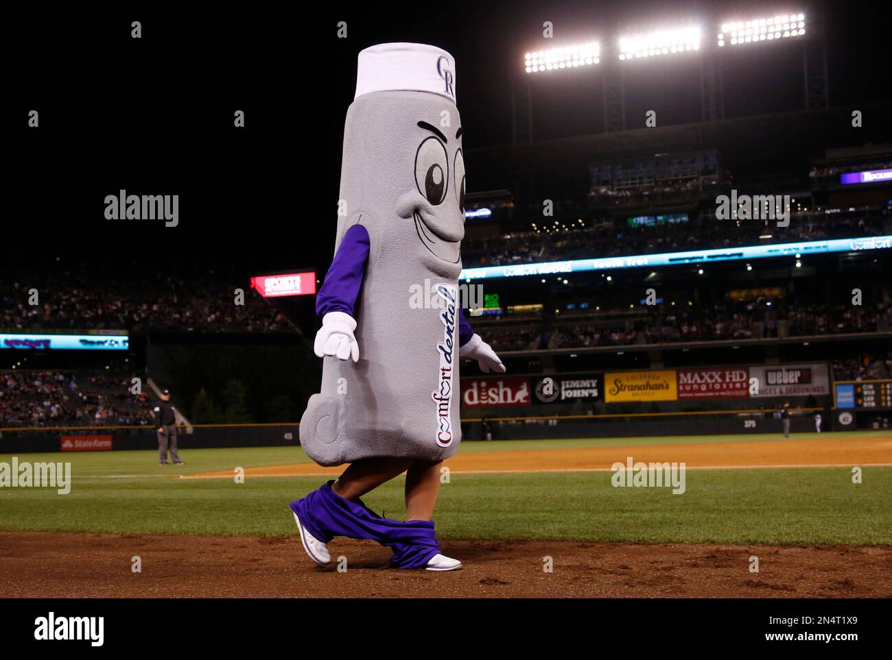 One of the three participants in the promotional race sponsored by a local dental firm, Fresh the tube of toothpaste, finds it difficult to run with his pants around his ankles in the eighth inning of the Rockies' 5-4 victory over the San Francisco Giants in a baseball game in Denver on Tuesday, May 20, 2014. (AP Photo/David Zalubowski) Banque D'Images