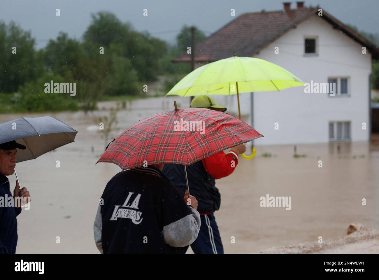 Bosnian men walk through a flooded street in a suburb of Sarajevo on Wednesday May 14, 2014. Heavy rainfall caused the river Bosna to flood surrounding areas causing power cuts and road blockades in some suburban and rural areas. (AP Photo/Amel Emric) Banque D'Images