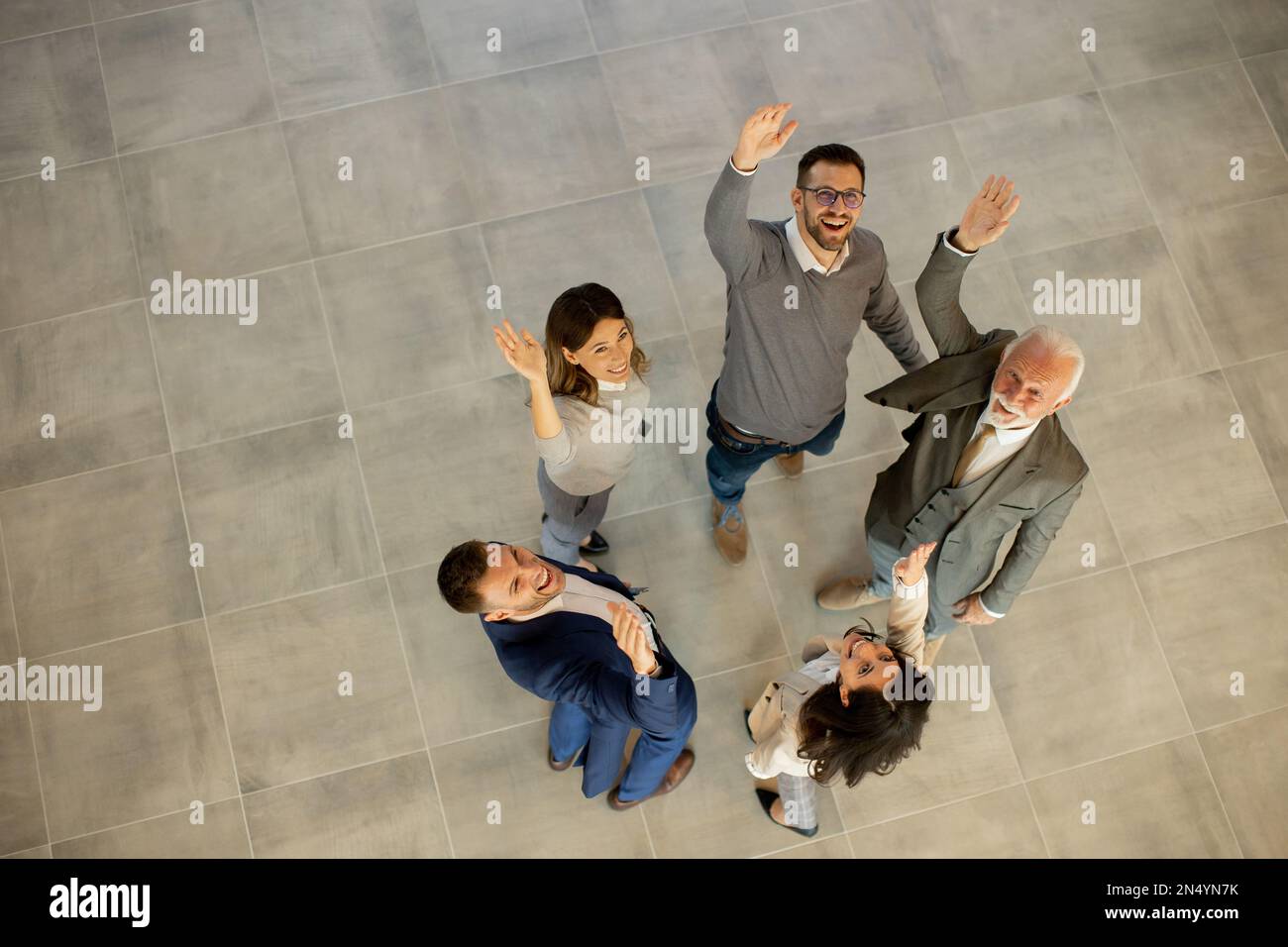 La vue aérienne des gens d'affaires heureux lève les mains avec joie et succès dans le couloir du bureau. Concept de réussite et de travail d'équipe Banque D'Images