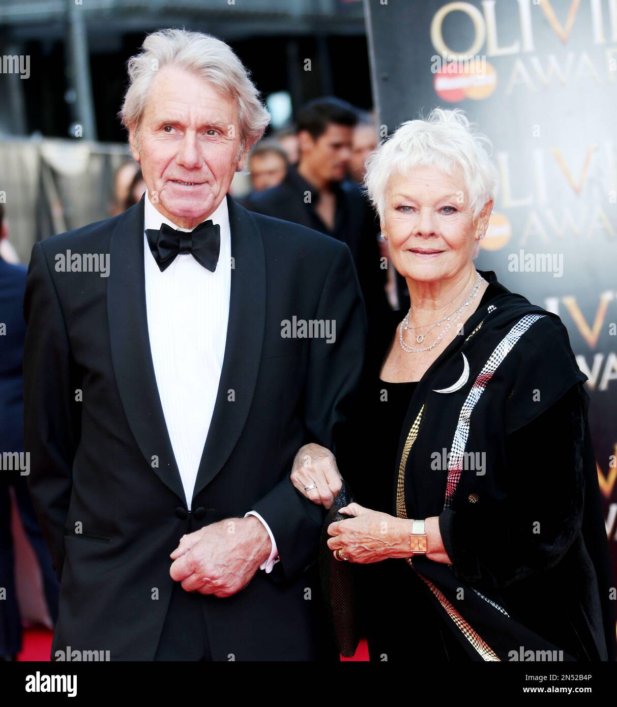 David Mills and Judi Dench arrives for the Olivier Awards at the Royal Opera House in central London, Sunday, April 13, 2014. Named after the British actor Laurence Olivier, the awards are given for West End shows and other productions staged in London.(Photo by Joel Ryan/Invision/AP Images) Banque D'Images