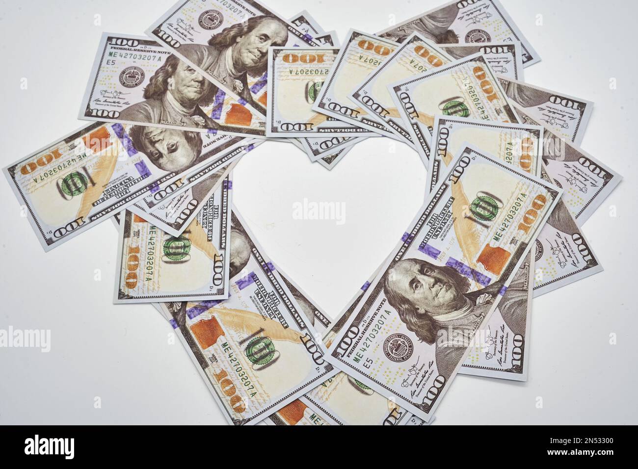 pour l'amour de l'argent coeur de forme cent billets de dollars sur fond blanc Banque D'Images