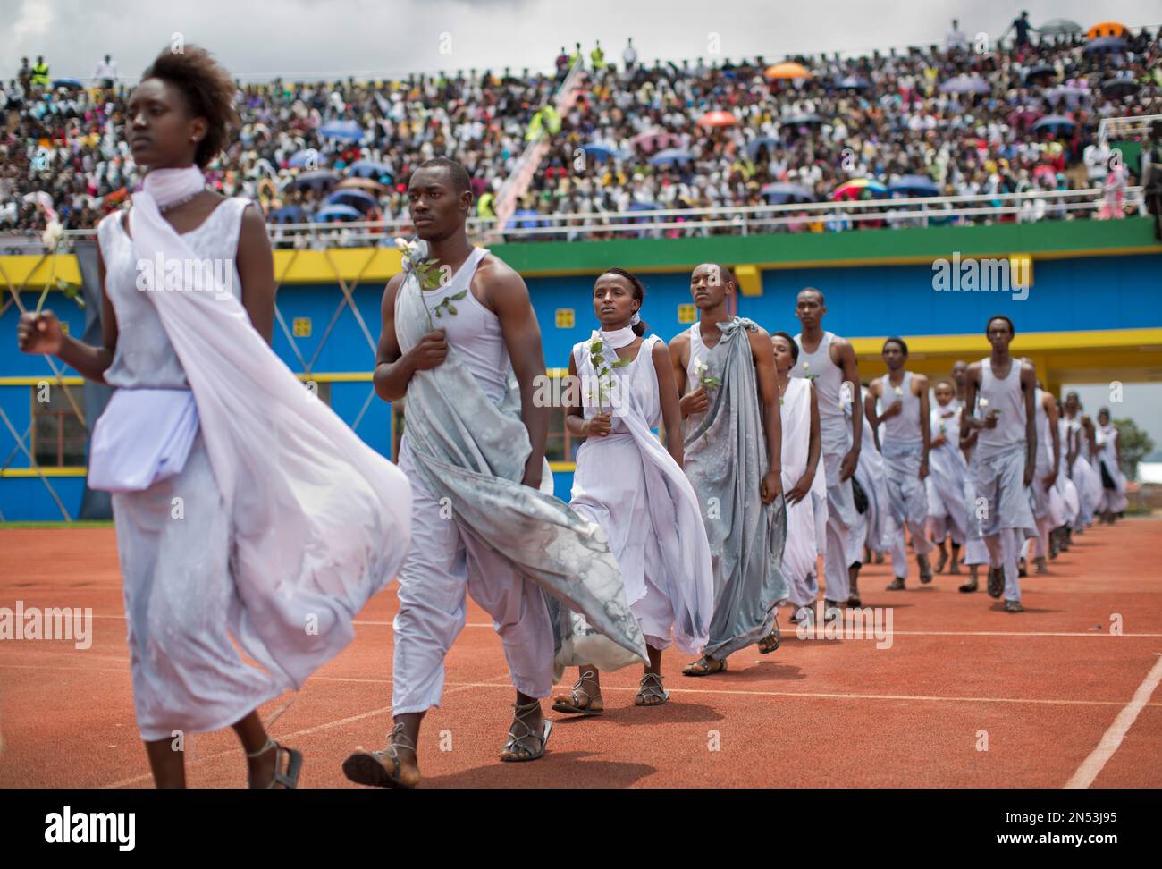Performers re-enacting some of the events enter a public ceremony to