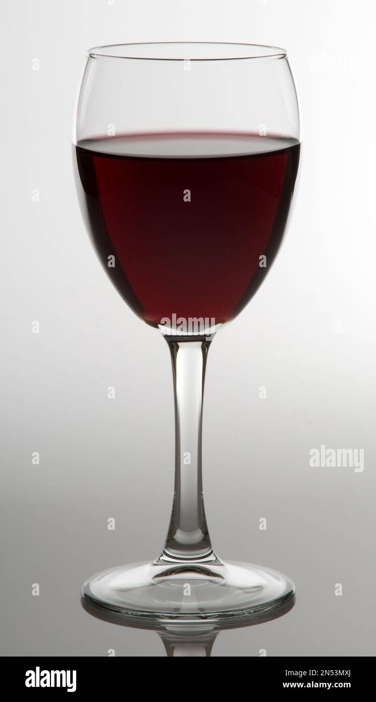 verre à vin à moitié plein isolé sur fond blanc éclairage à touches élevées Banque D'Images