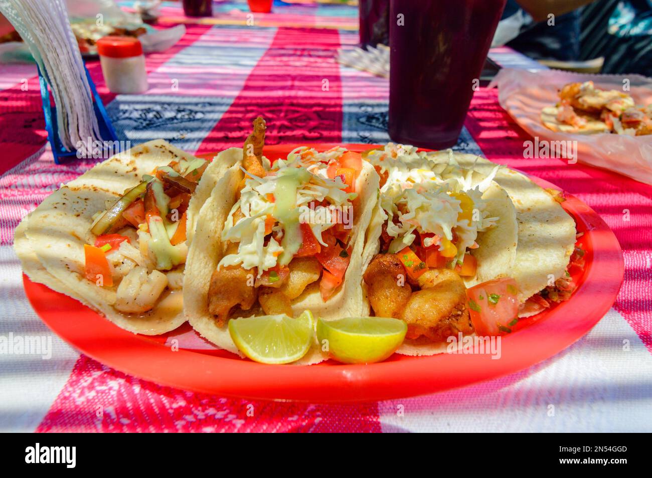 Tacos mexicains au poisson Baja à Todos Santos avec sauce fraîche sur fond coloré. Tacos de pétoncle, de marlin, de poisson blanc et de crevettes à la salsa de habanero Banque D'Images