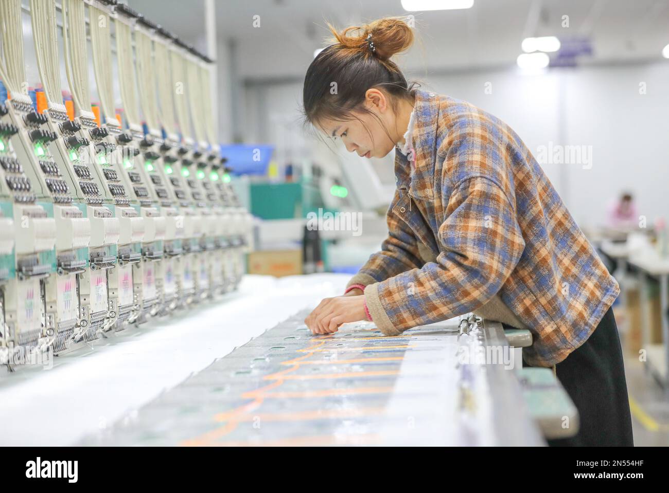 HUZHOU, CHINE - 9 FÉVRIER 2023 - Un travailleur travaille dans un atelier de broderie de Zhejiang Sanhe Line Technology Co., Ltd. Pour l'exportation en mer à Xin 'an Banque D'Images