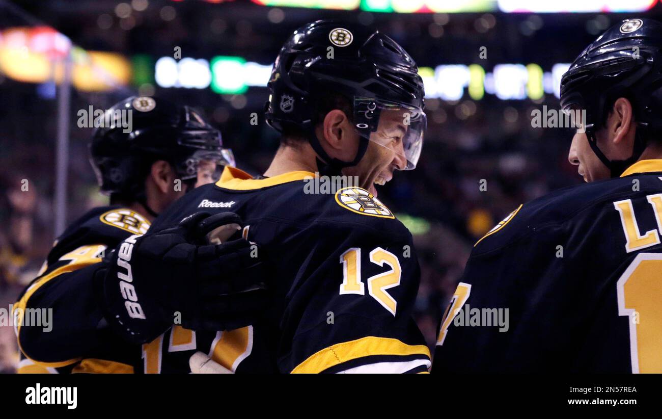 Boston Bruins right wing Jarome Iginla (12) smiles as he is congratulated by teammates after his goal during the second period of an NHL hockey game, Monday, March 17, 2014, in Boston. (AP Photo/Charles Krupa) Banque D'Images
