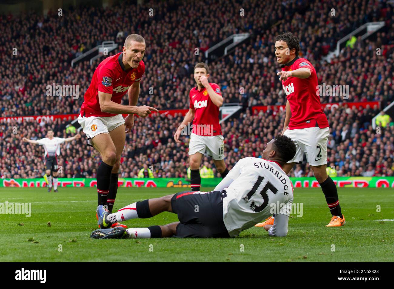 Manchester United's Nemanja Vidic, left, reacts with Liverpool's Daniel Sturridge, bottom, after a challenge which lead to a sending off for Vidic during their English Premier League soccer match at Old Trafford Stadium, Manchester, England, Sunday March 16, 2014. (AP Photo/Jon Super) Banque D'Images
