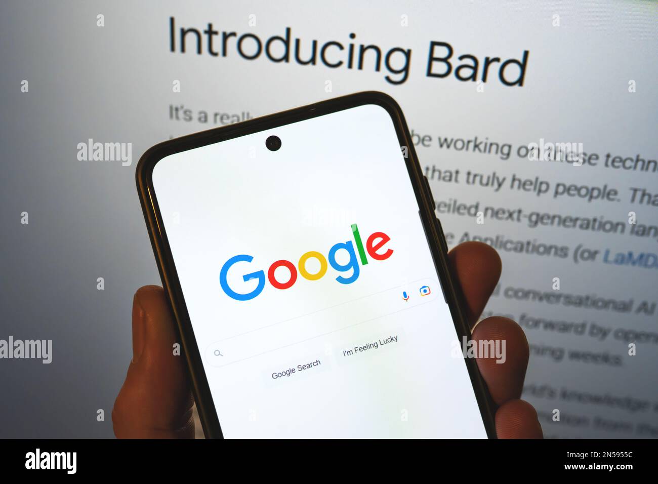 Google lance Bard ai. Barre de recherche Google sur un téléphone en main avec les informations de libération en arrière-plan. Google Bard ai contre OpenAI ChatGPT. Varsovie, Pologne - 8 février 2023. Banque D'Images