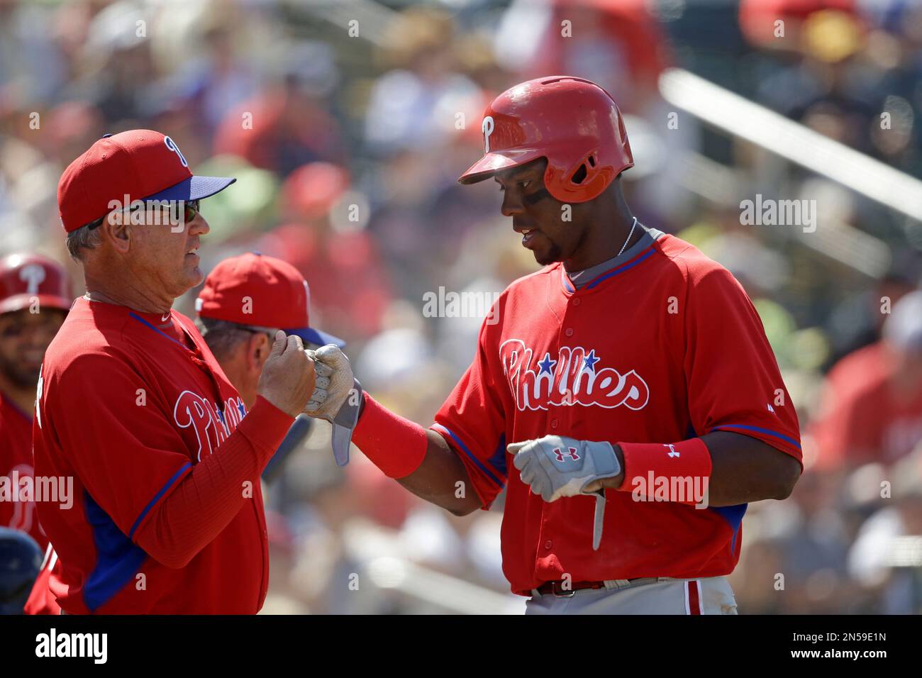 Philadelphia Phillies John Mayberry Jr. is greeted by manager Ryne Sandberg after scoring the tying run in the eighth inning of an exhibition baseball game against the Minnesota Twins in Fort Myers, Fla., Sunday, March 9, 2014. The game ended in a 1-1 tie. (AP Photo/Gerald Herbert) Banque D'Images