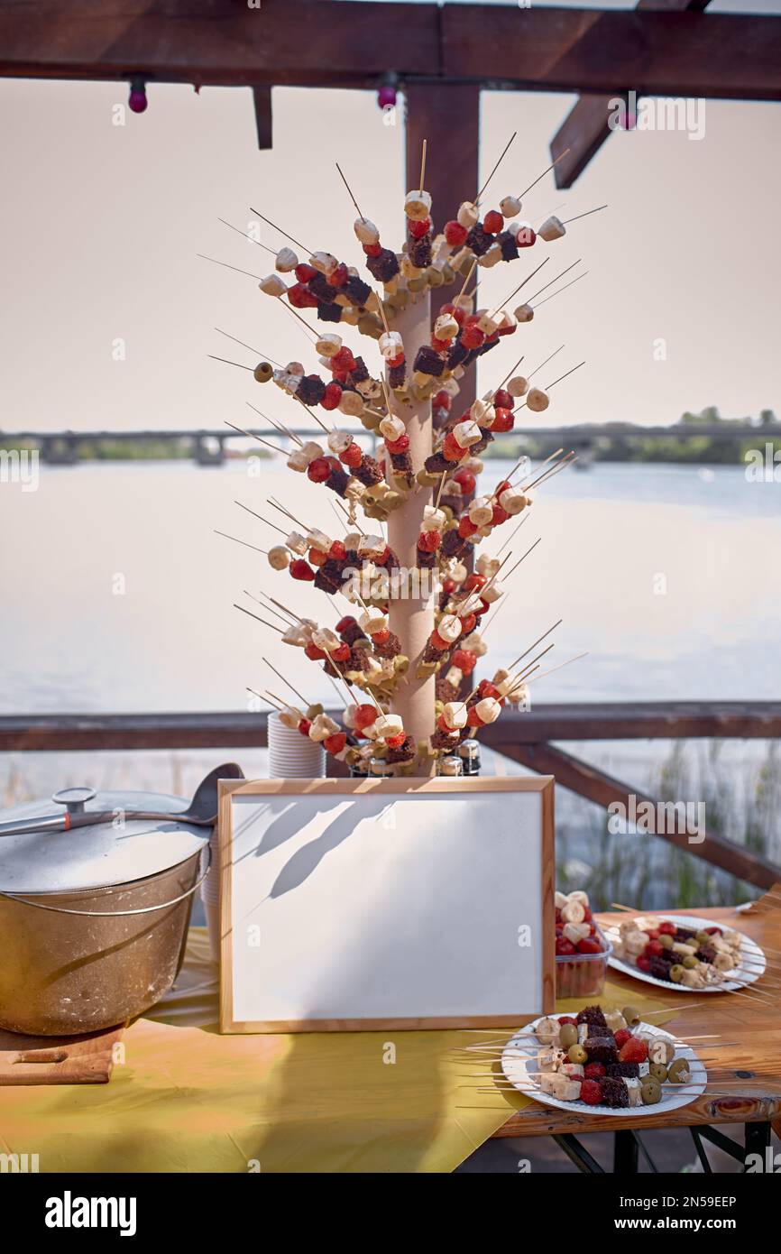 Fête d'été avec légumes brochés grillés barbecue avec cadre en maquette devant la rivière. Banque D'Images