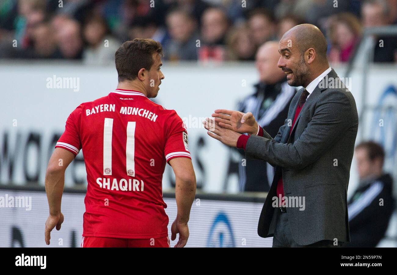 Bayern head coach Pep Guardiola of Spain, right, speaks to Bayern's Xherdan Shaqiri of Switzerland during the German Bundesliga soccer match between VfL Wolfsburg and Bayern Munich inWolfsburg, Germany, Saturday, March 8, 2014. (AP Photo/Gero Breloer) Banque D'Images