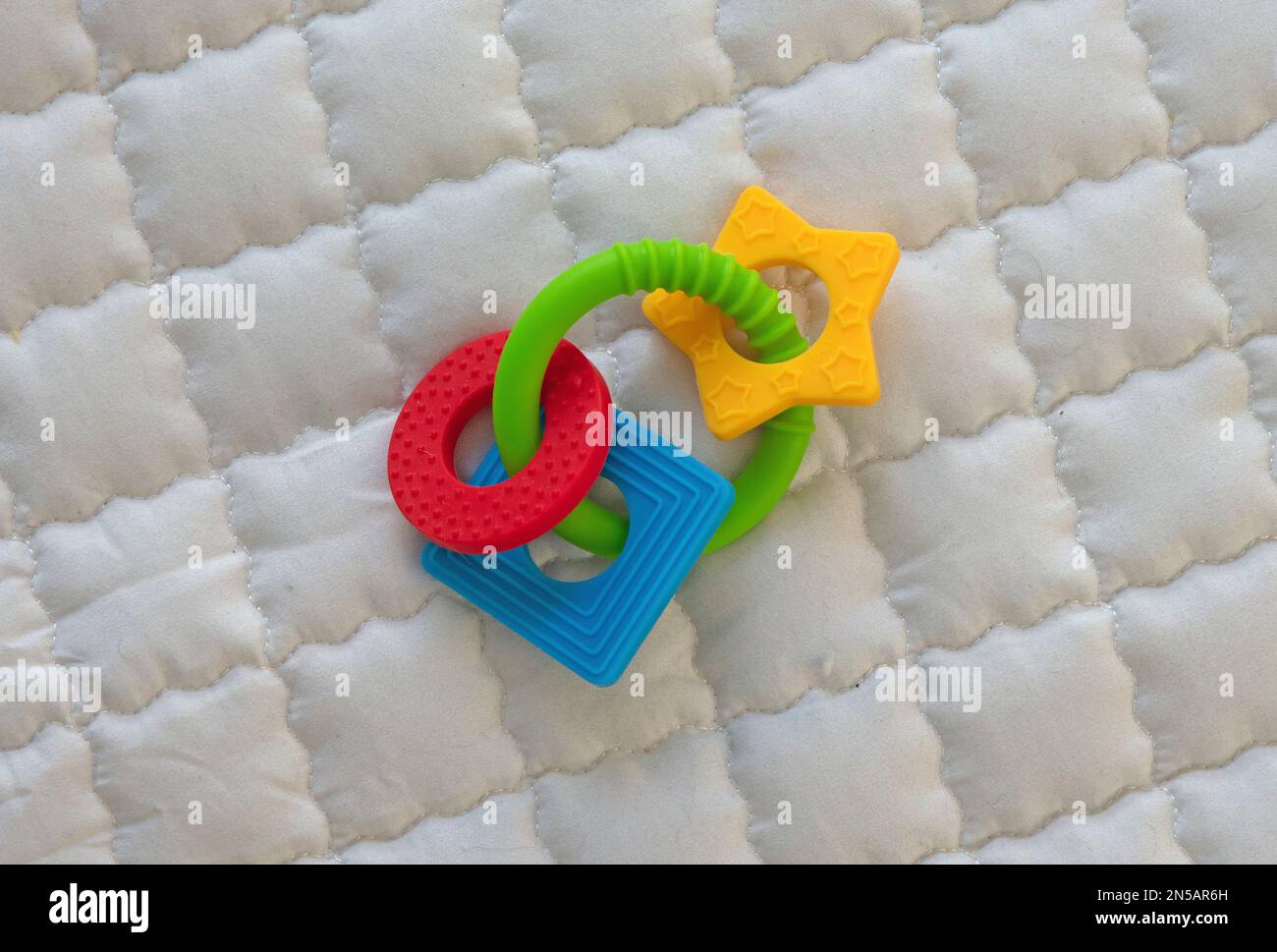 Anneau de dentition en silicone pour bébé isolé sur un tapis de jeu pour bébé Banque D'Images