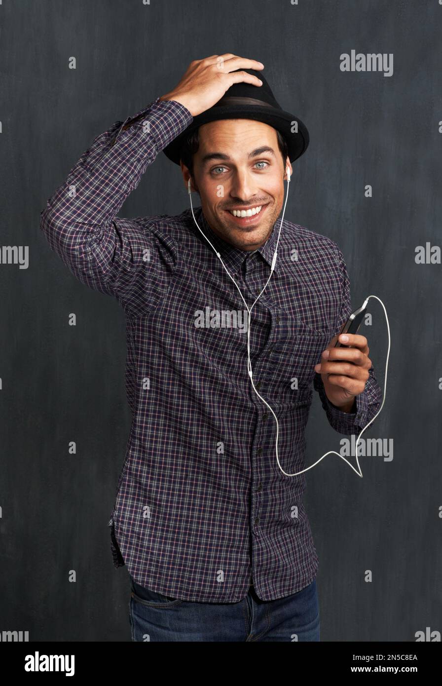HES aime la musique. Portrait d'un jeune homme branché qui écoute de la musique sur son téléphone portable. Banque D'Images