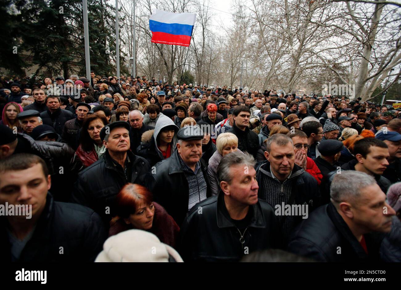 Pro-Russian protesters wave Russia's flag gathered in front of city hall in the Ukrainian Black Sea port of Sevastopol in the Crimea, Monday, Feb. 24, 2014. Ukraine's acting government issued an arrest warrant Monday for President Viktor Yanukovych, accusing him of mass crimes against the protesters who stood up for months against his rule. Yanukovych himself has reportedly fled to pro-Russian Black Sea peninsula of Crimea. (AP Photo/Darko Vojinovic) Banque D'Images