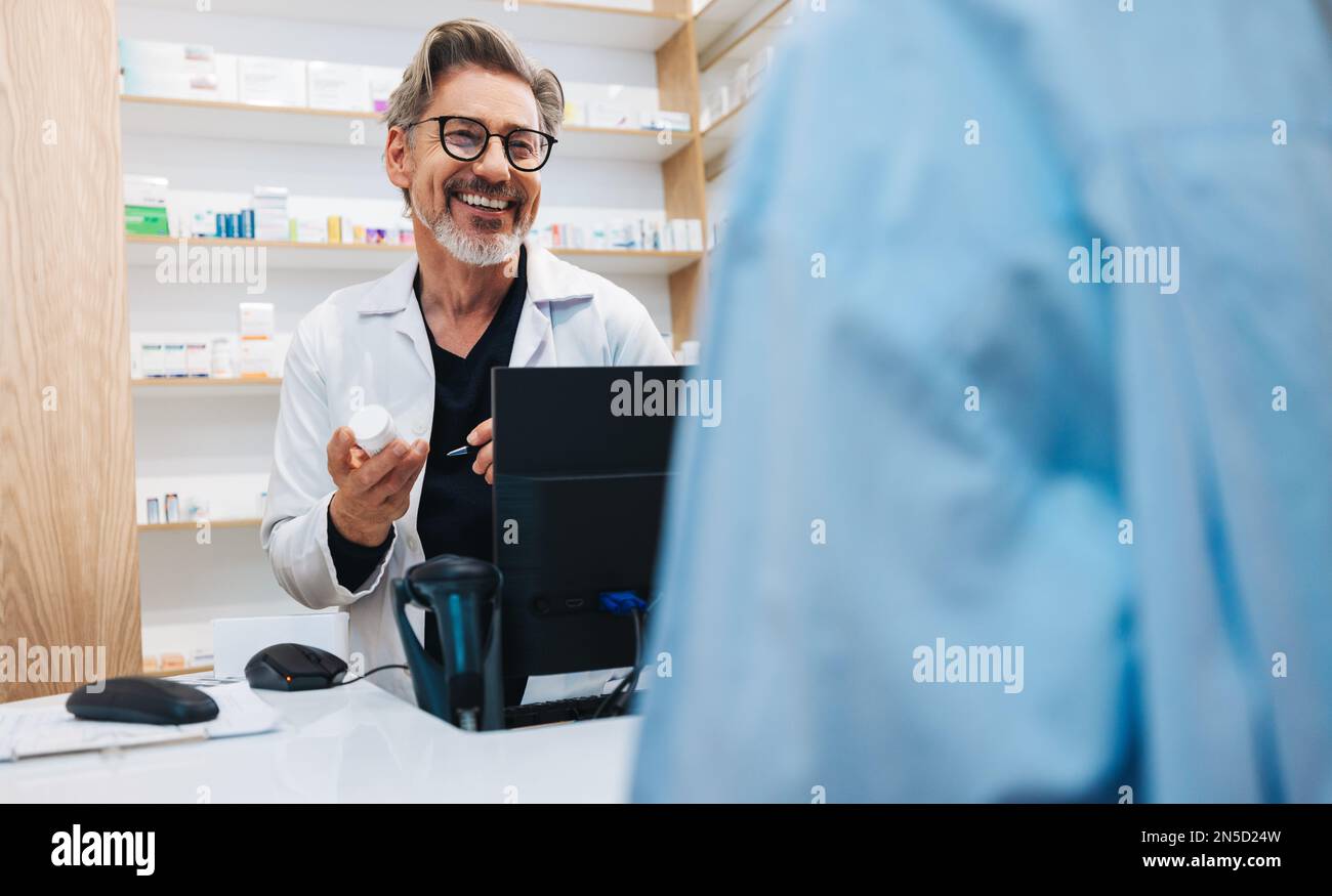 Pharmacien aidant un patient à obtenir une ordonnance d'un médecin dans un pharmacien. Fournisseur de soins de santé principal distribuant des médicaments dans une pharmacie. Banque D'Images