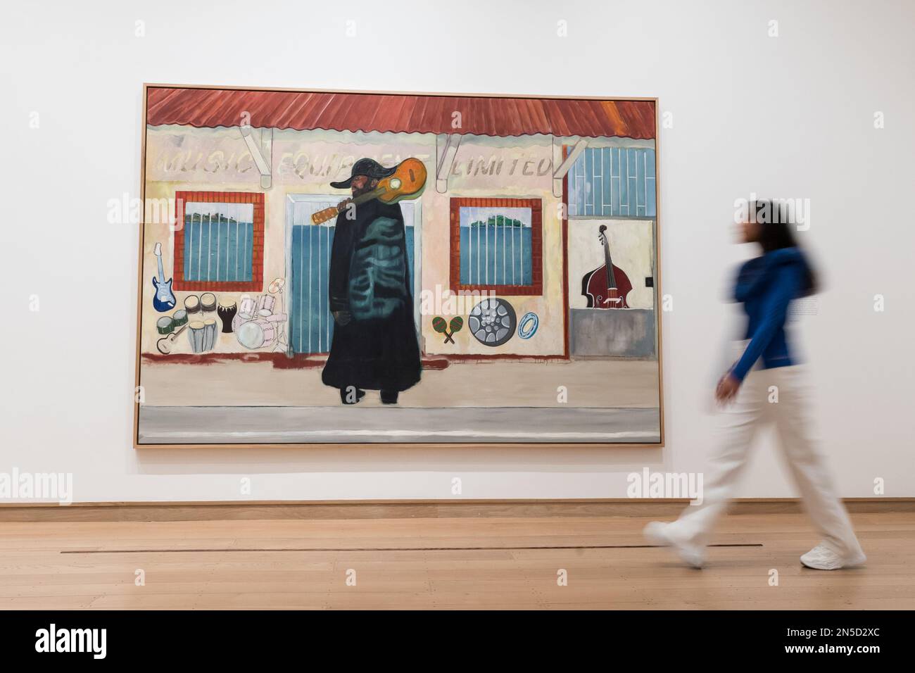 LONDRES, ROYAUME-UNI - 09 FÉVRIER 2023 : Un membre du personnel de la galerie passe devant un tableau intitulé 'Music Shop' (2019-23) de Peter Doig (né en 1959), lors d'une séance photo pour la grande exposition des œuvres récentes et nouvelles de Peter Doig à la galerie Courtauld de Londres, Royaume-Uni sur 09 février 2023. Exposition Morgan Stanley : Peter Doig (10 février - 29 mai 2023) présentera un nouveau chapitre passionnant dans la carrière de l'un des peintres les plus célèbres et les plus importants qui travaillent aujourd'hui et la première exposition d'un artiste contemporain à avoir lieu au Courtauld depuis sa réouverture à 20 novembre Banque D'Images