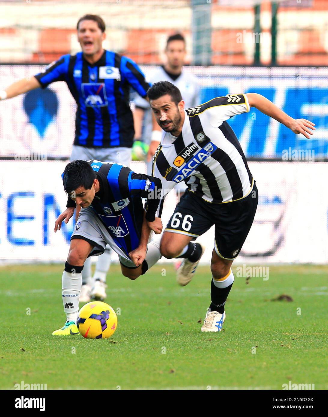 Atalanta's Maximiliano Moralez, left, and Udinese's Giampiero Pinzi, fight for the ball during the Serie A soccer match between Udinese and Atalanta at the Friuli Stadium in Udine, Italy, Sunday, Feb. 23, 2014. (AP Photo/Paolo Giovannini) Banque D'Images