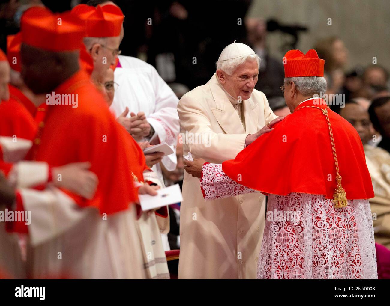 Newly-elected Cardinal Orlando Quevedo, Archbishop of Cotabato, Philippines, is greeted by Pope Emeritus Benedict XVI after he received the red three-cornered biretta hat by Pope Francis during a consistory inside the St. Peter's Basilica at the Vatican, Saturday, Feb.22, 2014. (AP Photo/Alessandra Tarantino) Banque D'Images