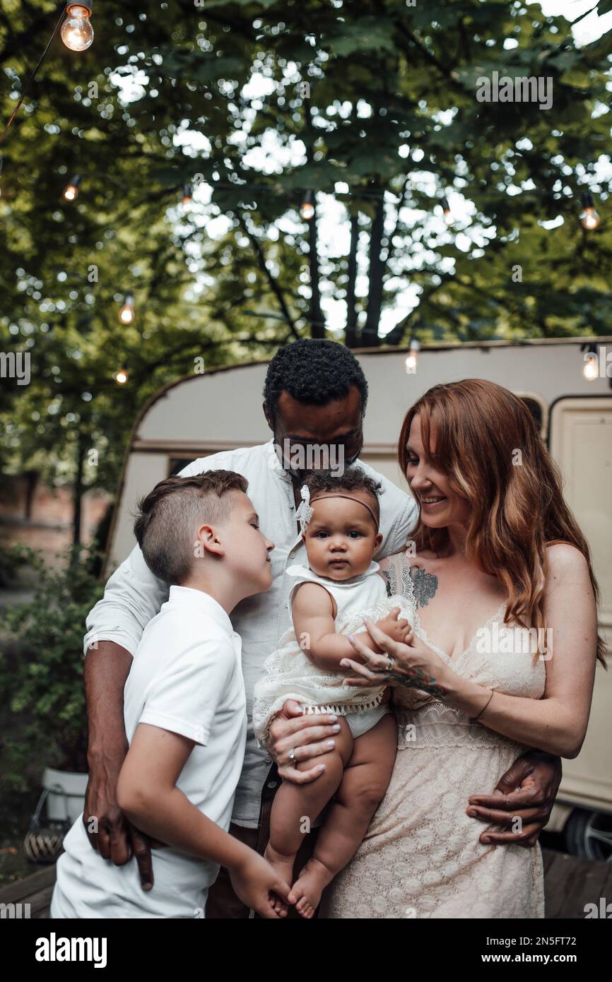 Une famille de race mixte avec son fils blanc et sa fille naissante passent du temps ensemble dans le camping-car à l'extérieur. Homme afro-américain avec sa juste peau wi Banque D'Images