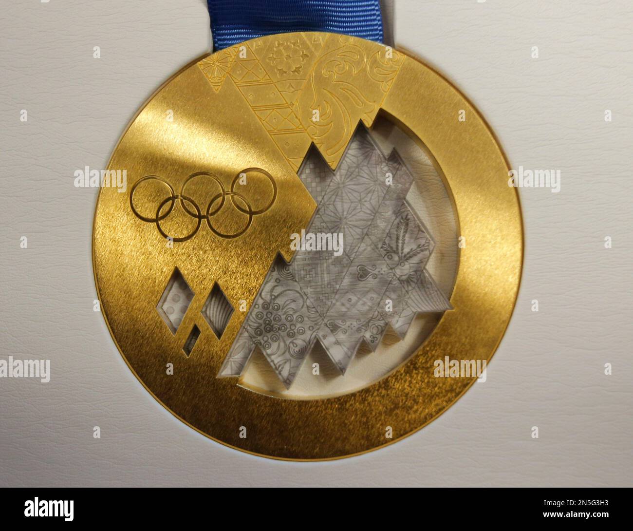 FILE - In this May 30, 2013 file photo, the gold medal is displayed for journalists during a presentation of Sochi 2014 Olympic medals in St. Petersburg, Russia. When an athlete wins a gold medal in Sochi, the prize money they receive back home can vary widely, depending on which country they're from. Kazakhstan tops the list, offering gold medal winners $250,000. The United States and Canada offer far less, with rewards of $25,000 and $18,000 respectively. (AP Photo/Dmitry Lovetsky, File) Banque D'Images