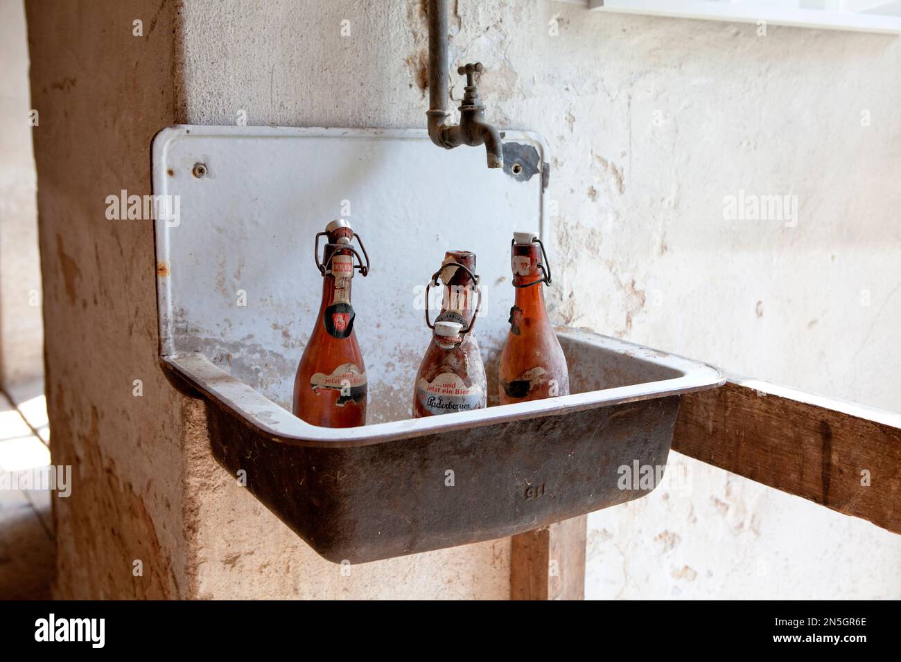 vieilles bouteilles de bière debout sur un lavabo Banque D'Images