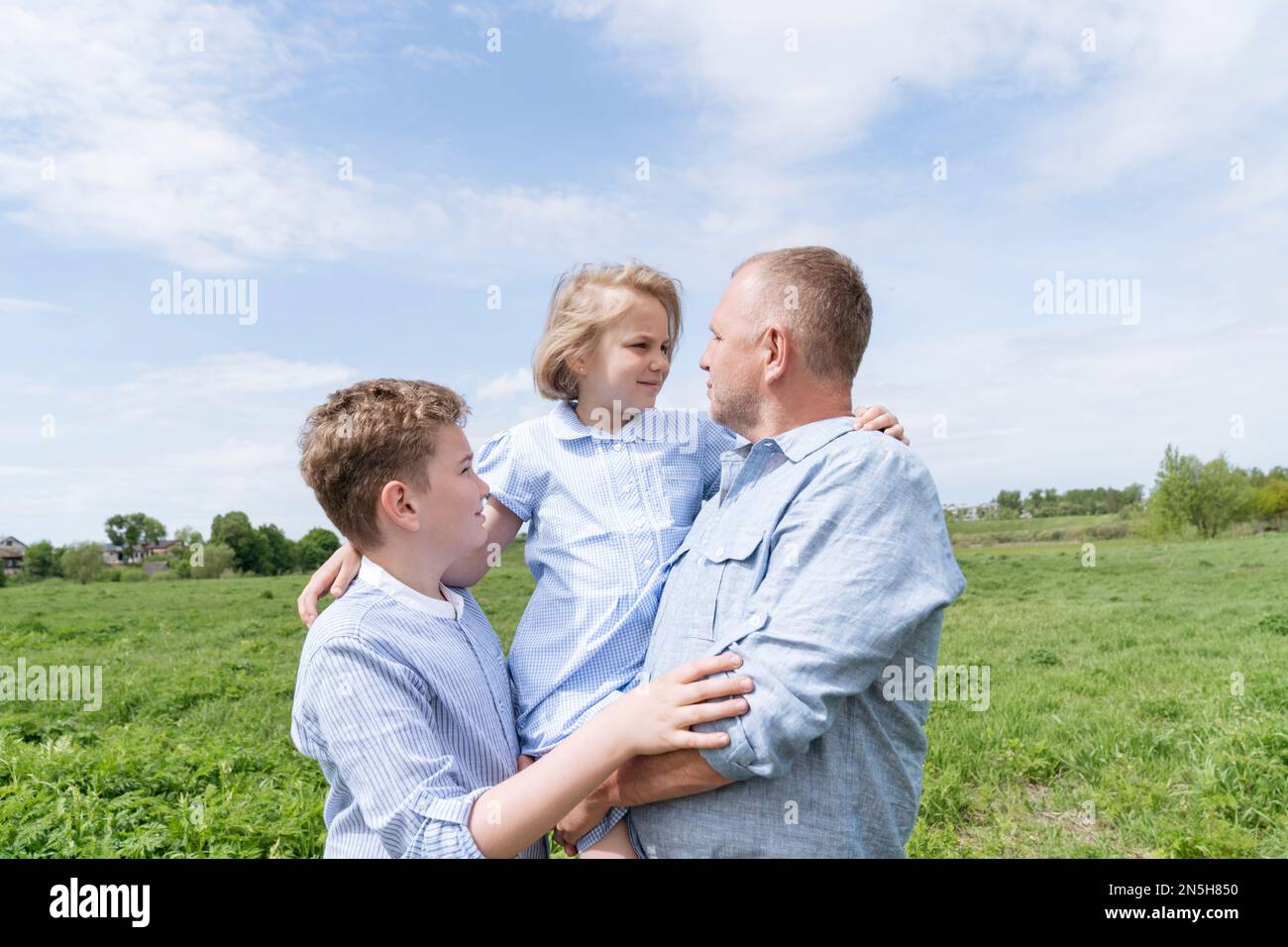 Homme mature marchant dans la nature avec deux enfants. Banque D'Images