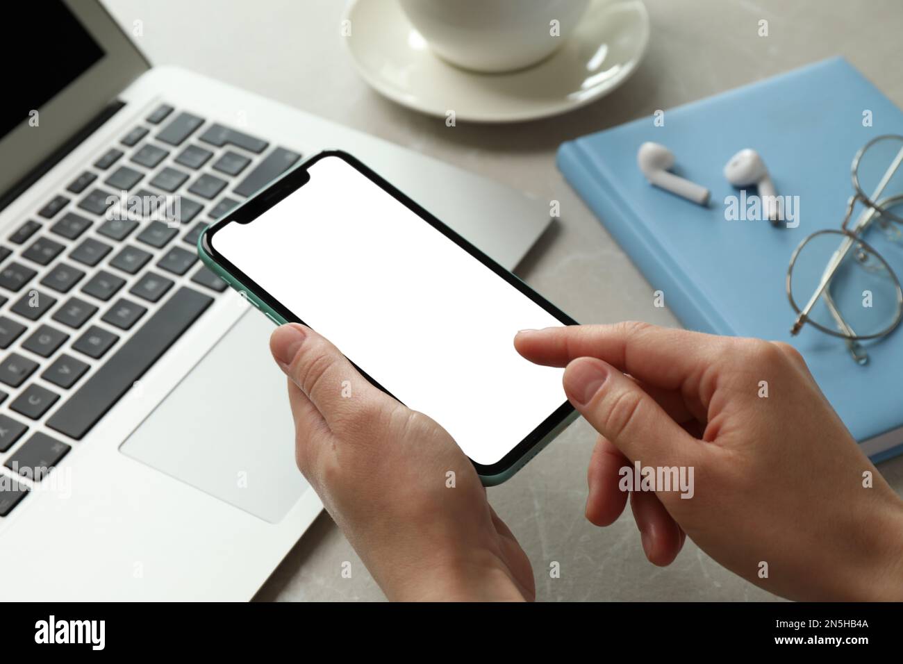 MYKOLAIV, UKRAINE - 8 JUILLET 2020: Femme utilisant l'iPhone 11 Pro Max avec écran vide sur le lieu de travail, gros plan Banque D'Images