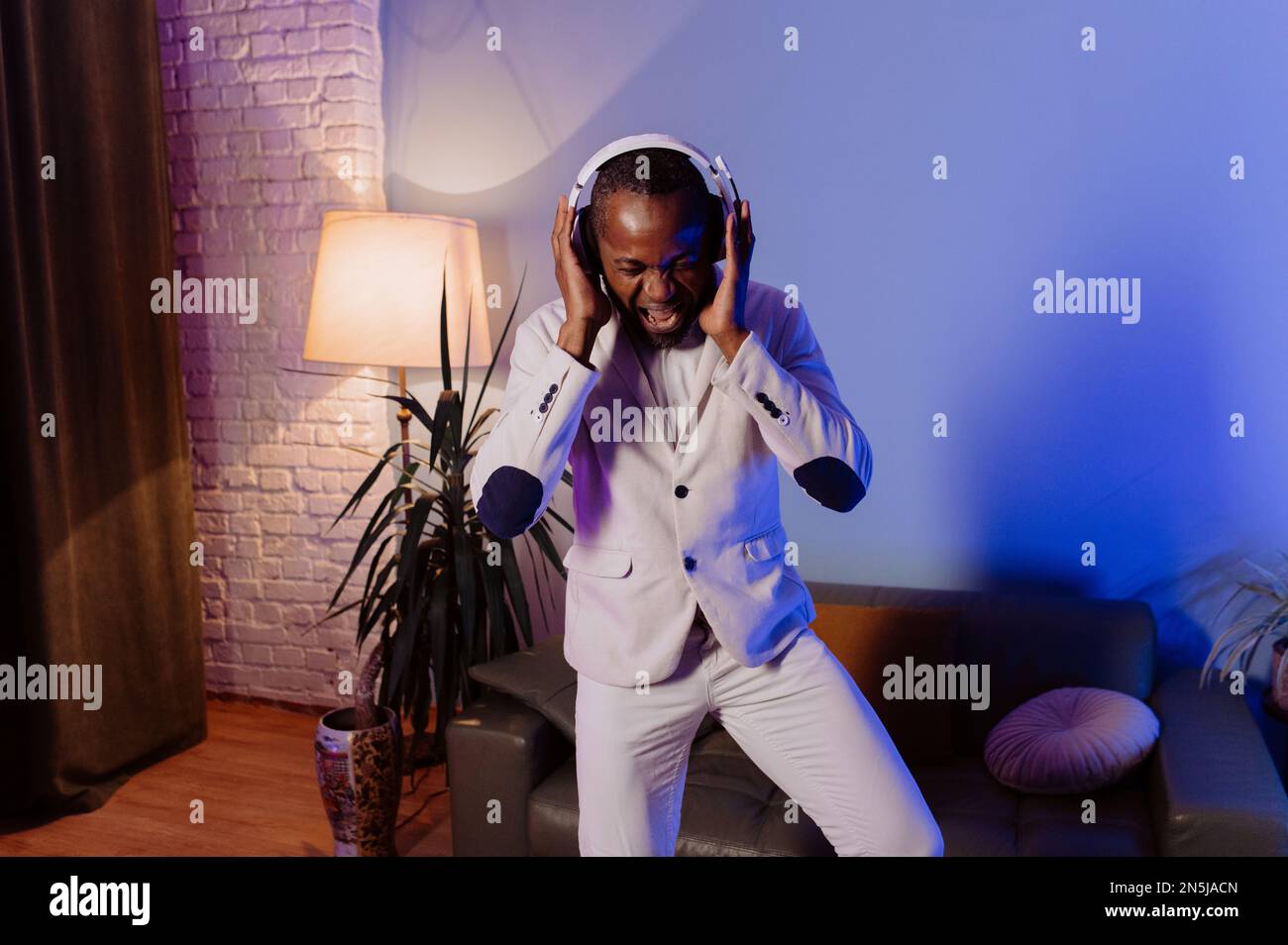 Homme noir décontracté dans le casque. Un homme écoute de la musique à la maison. Homme afro-américain appréciant la musique Banque D'Images