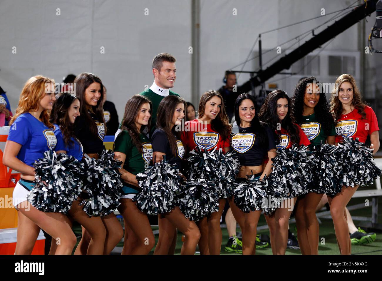 Former NFL player Jesse Palmer poses with cheerleaders at the Tazon